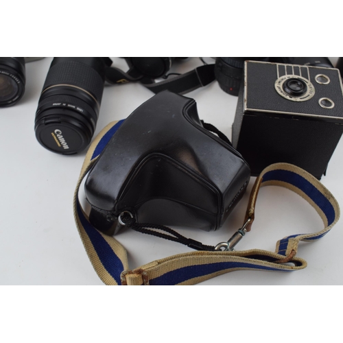 422 - A collection of vintage cameras and lenses to include Olympus OM10, Canon EOS and FinePix cameras to... 