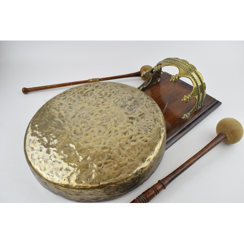 526 - Wall mountable dinner gong with brass mount and gong. Height 44cm.