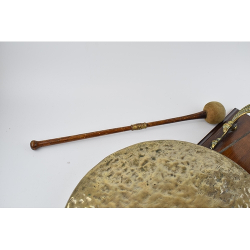 526 - Wall mountable dinner gong with brass mount and gong. Height 44cm.