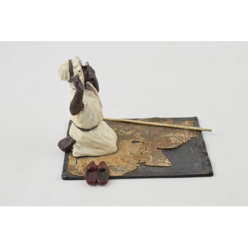 533 - A vintage novelty hand-painted spelter model of a man knelling of prayer mat. Sprung head. Baes 7cm ... 