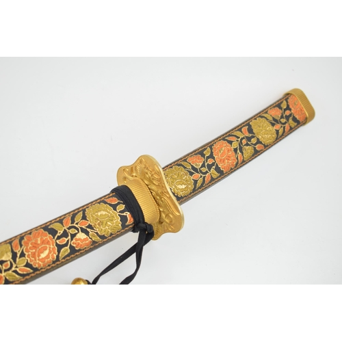 556 - A vintage decorative Samurai sword in embroidered sheath, engraved blade and brass hilt. Length 96cm... 