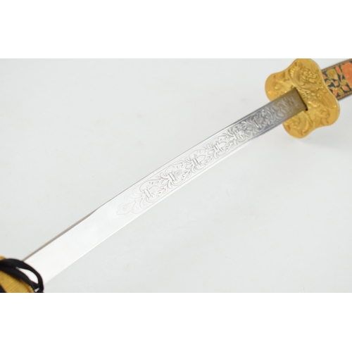 556 - A vintage decorative Samurai sword in embroidered sheath, engraved blade and brass hilt. Length 96cm... 