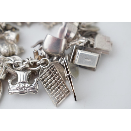 366 - Silver charm bracelet with large number of mainly silver charms, weight 92.2g.