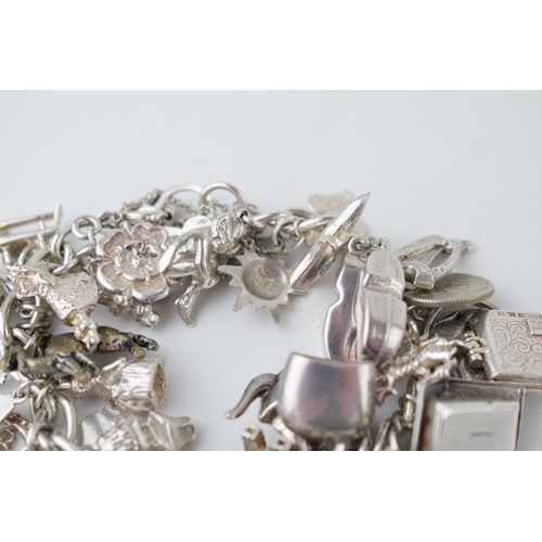 366 - Silver charm bracelet with large number of mainly silver charms, weight 92.2g.