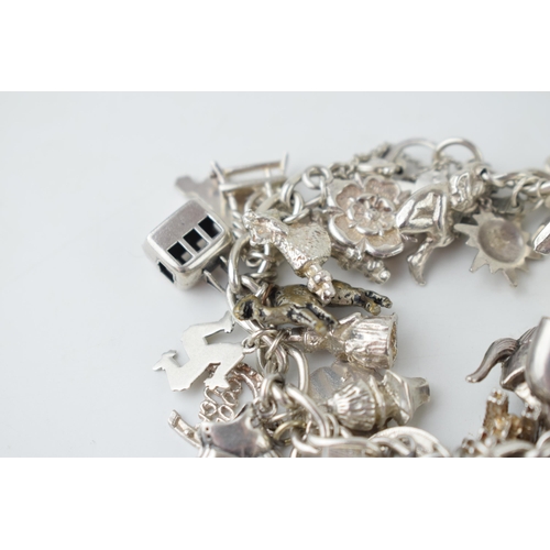 366 - Silver charm bracelet with large number of mainly silver charms, weight 92.2g.