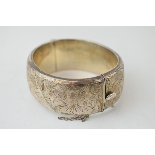 387 - Wide silver bangle with engraved floral decoration, 40.9 grams, 7cm diameter, Birm 1962.