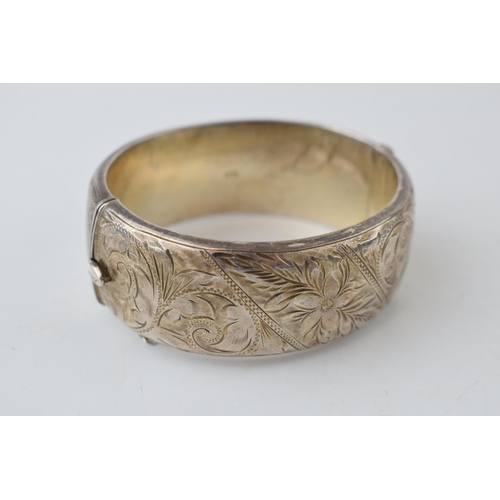 387 - Wide silver bangle with engraved floral decoration, 40.9 grams, 7cm diameter, Birm 1962.