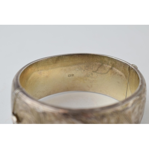 387 - Wide silver bangle with engraved floral decoration, 40.9 grams, 7cm diameter, Birm 1962.