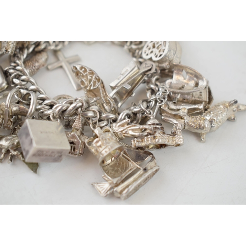 388 - Large silver charm bracelet, heavy, to include charms such as a camel, a crocodile, a castle and oth... 