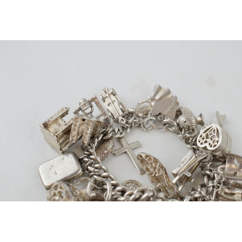 388 - Large silver charm bracelet, heavy, to include charms such as a camel, a crocodile, a castle and oth... 