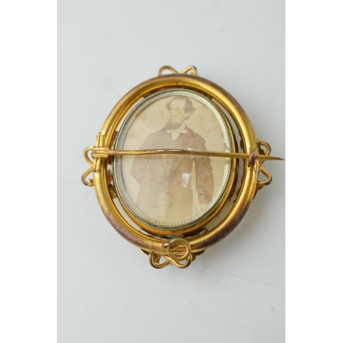 385 - Victorian pinchbeck mourning brooch, with swivelling cased photos, 5.5cm tall.