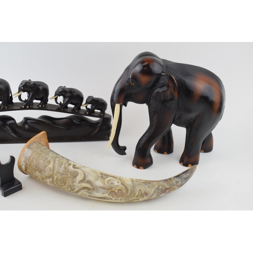 540 - Carved elephant with bone tusks, a carved horn and a stand together with row of five elephants in ha... 