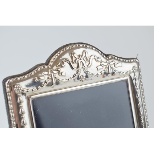 300 - Silver ornate photo frame with ribbon and bow decoration, 24.5cm tall, easel-back, Sheffield 1996.