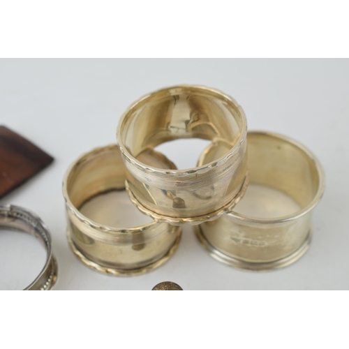 321 - A collection of silver items to include napkin rings, thimble, fob and sugar nips (approx 90 grams) ... 