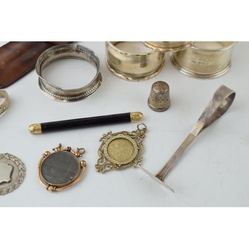 321 - A collection of silver items to include napkin rings, thimble, fob and sugar nips (approx 90 grams) ... 