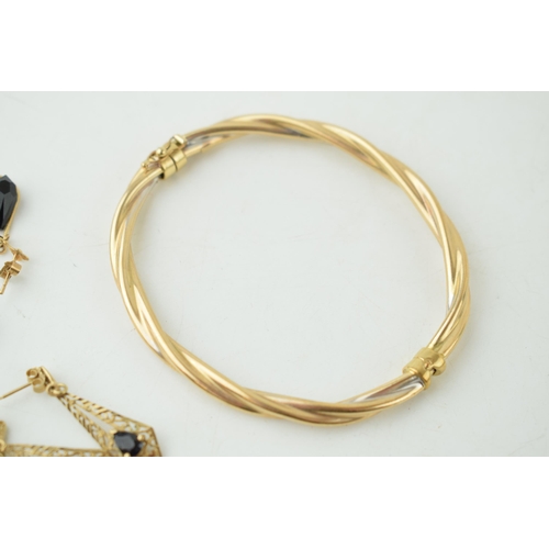 335 - A 9ct gold bangle (7.1 grams) together with a collection of yellow coloured metal earrings with semi... 