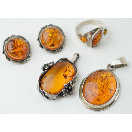 350 - A collection of silver mounted amber jewellery to include a pendant, with another floral mounted exa... 