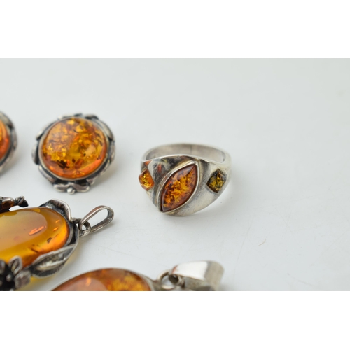 350 - A collection of silver mounted amber jewellery to include a pendant, with another floral mounted exa... 