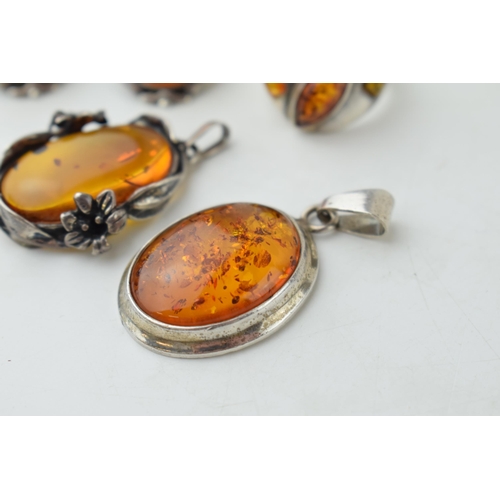 350 - A collection of silver mounted amber jewellery to include a pendant, with another floral mounted exa... 