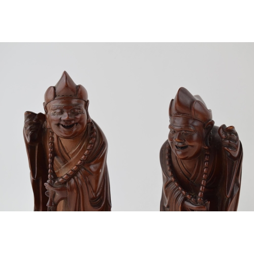 395 - A pair of oriental smiling figures, wooden, 22.5cm tall (2).