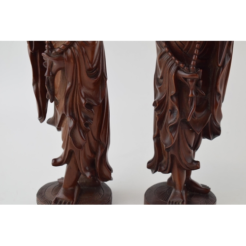 395 - A pair of oriental smiling figures, wooden, 22.5cm tall (2).