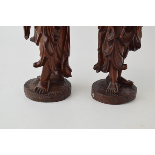 395 - A pair of oriental smiling figures, wooden, 22.5cm tall (2).