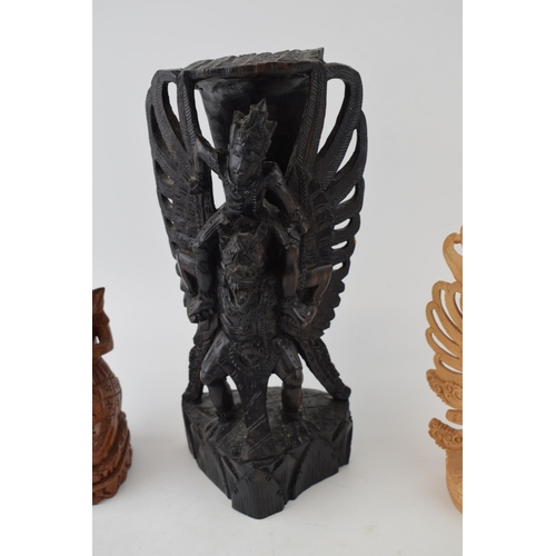 538 - Three carvings of deities from Bali. In different woods. (3) Height 25cm.