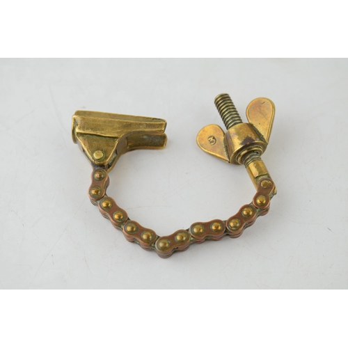 559 - Antique brass novelty bottle top remover, tension and screw type movement, 14cm long.