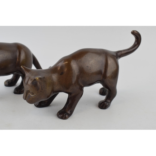 562 - A pair of bronze stylised cats. Height 14cm.