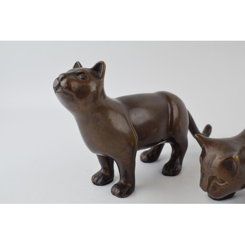 562 - A pair of bronze stylised cats. Height 14cm.