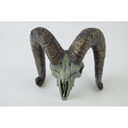 565 - A cast metal sculpture of a rams skull and horns, signed 'F Boyer 98', 12cm wide.