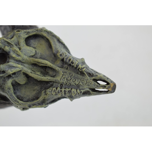 565 - A cast metal sculpture of a rams skull and horns, signed 'F Boyer 98', 12cm wide.