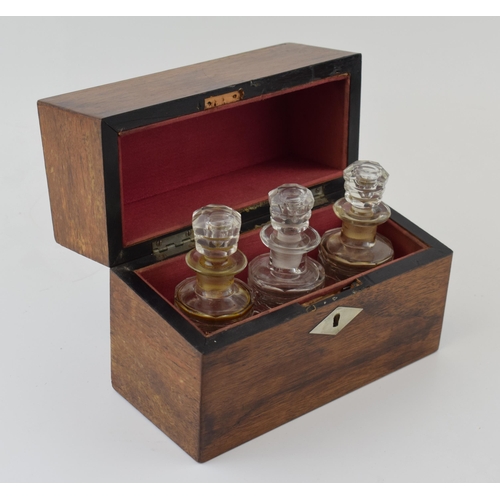 629 - A 19th century boxed scent bottle holder with three original glass bottles with stoppers. Red velvet... 