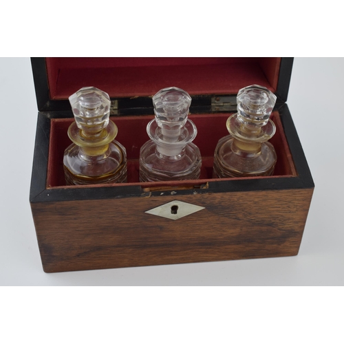 629 - A 19th century boxed scent bottle holder with three original glass bottles with stoppers. Red velvet... 