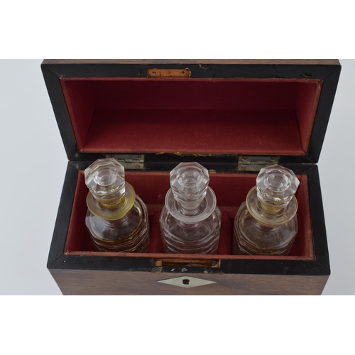 629 - A 19th century boxed scent bottle holder with three original glass bottles with stoppers. Red velvet... 