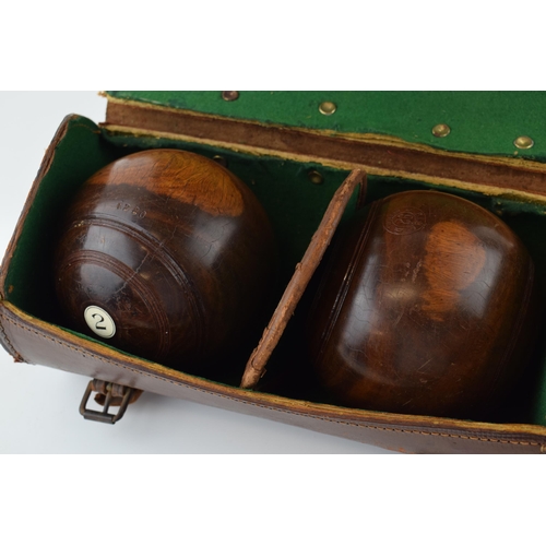 635 - A set of vintage lignum vitae bowl in original leather carry case.