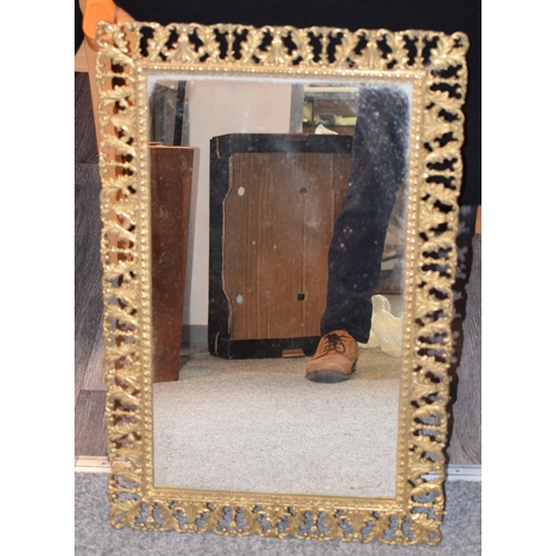 645 - An antique style decorative brass framed mirror, a heavy example, 43cm x 67cm.