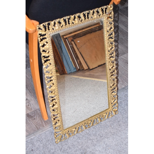 645 - An antique style decorative brass framed mirror, a heavy example, 43cm x 67cm.