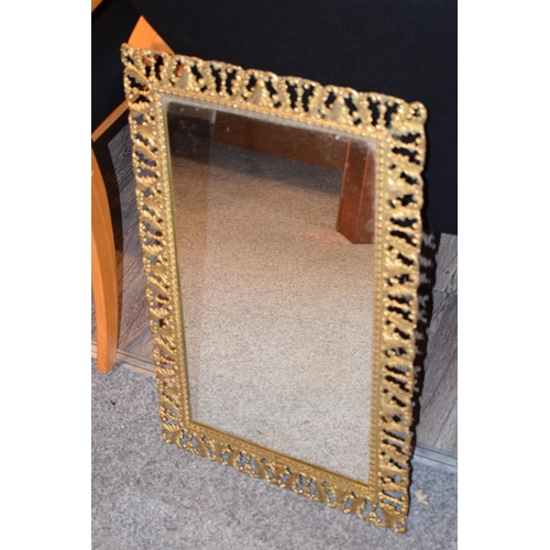 645 - An antique style decorative brass framed mirror, a heavy example, 43cm x 67cm.