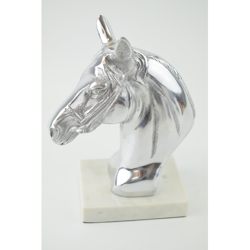 667 - A contemporary aluminium bust in the form of a horse's head on a white marble base, 23.5cm tall.