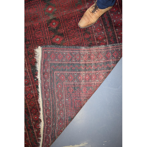 582 - A hand-knotted oriental / middle-eastern carpet / rug in deep reds, blue and blacks. 111cm x 205cm.