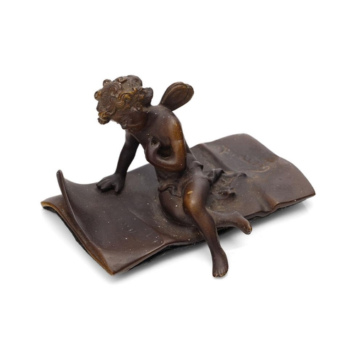 84 - Ernest Justin Ferrand (French 1846-1932) a small patinated bronze figure of cupid seated on a letter... 