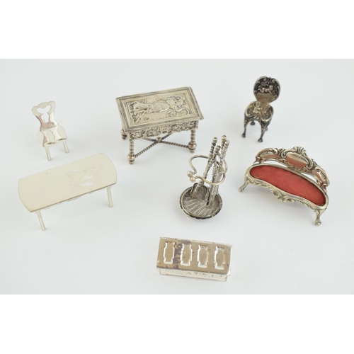 221 - A collection of miniature silver furniture to include a grand sofa, Birm 1902, a .930 silver heavily... 