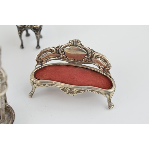 221 - A collection of miniature silver furniture to include a grand sofa, Birm 1902, a .930 silver heavily... 