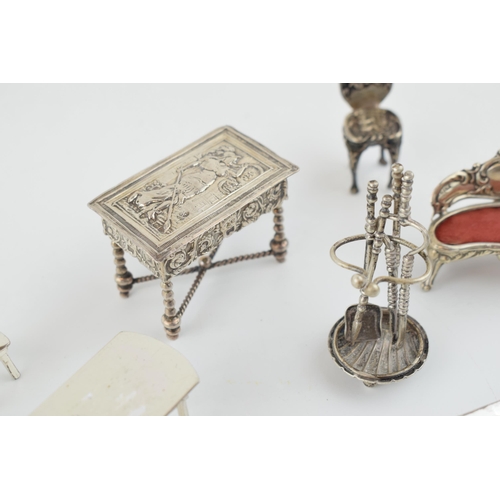 221 - A collection of miniature silver furniture to include a grand sofa, Birm 1902, a .930 silver heavily... 