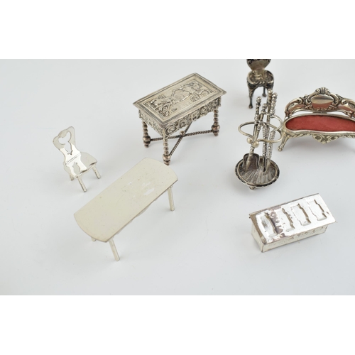 221 - A collection of miniature silver furniture to include a grand sofa, Birm 1902, a .930 silver heavily... 