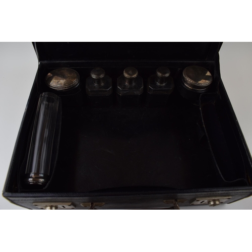 228 - A leather cased travelling case to include 6 silver topped jars of varying sizes and forms with indi... 