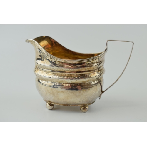 254 - George III silver cream jug, engraved decoration, sat on four ball feet, London 1809, 102.0 grams.