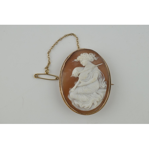 267 - 9ct gold cameo brooch, a lady with a violon, 11.1 grams, metal pin and safety chain, 48mm tall.