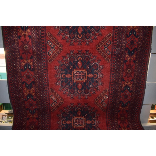 76 - A oriental / middle-eastern runner carpet / rug in deep reds, blues, oranges and cream. 83cm x 390cm... 